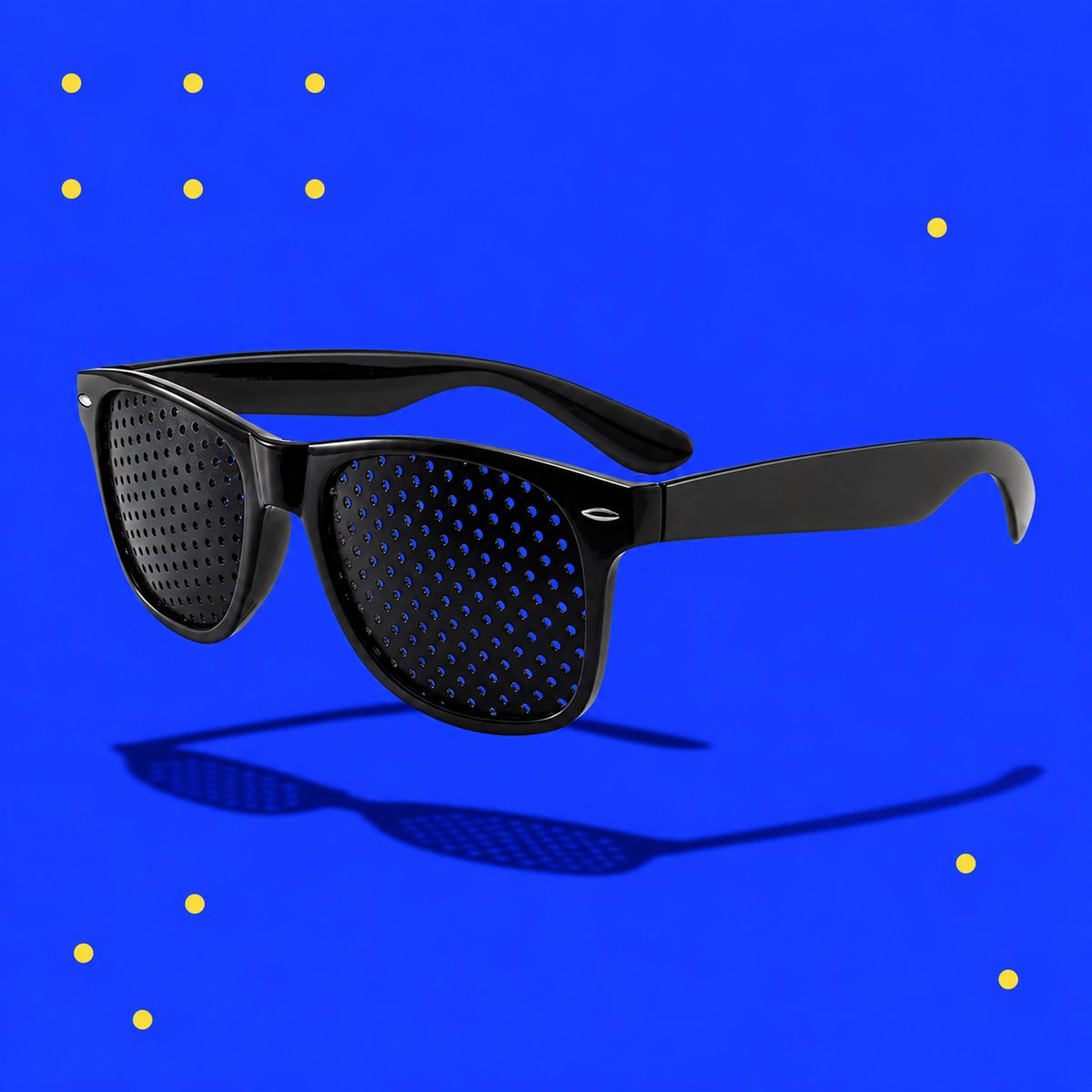 Black pinhole glasses floating on a bright blue background